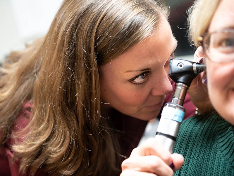 Hearing specialist inspecting a child's ear prior to hearing assessment